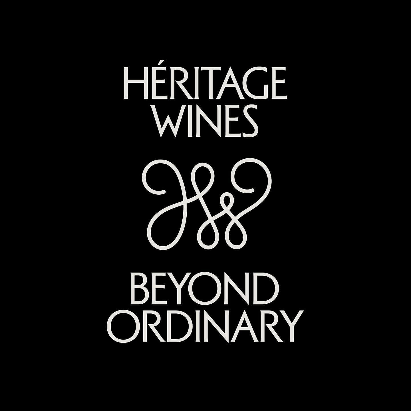 Heritage Wines elegant calligraphic monogram with thin serif type on solid black background